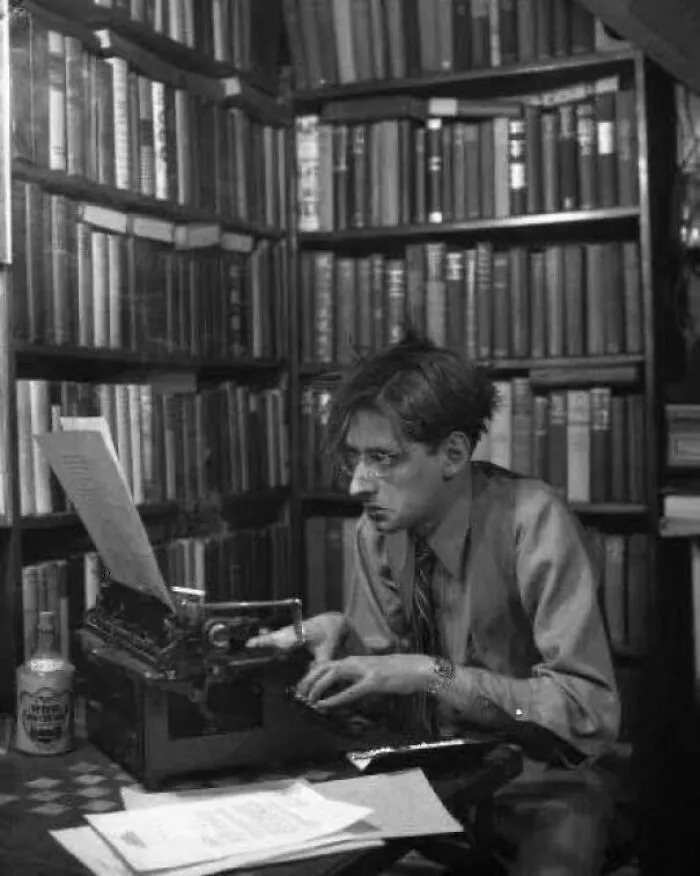رابرت بلاک در دهه ۱۹۵۰ پشت ماشین تحریر در کتابخانه خانگیاش | Robert Bloch typing in his home library, 1950s