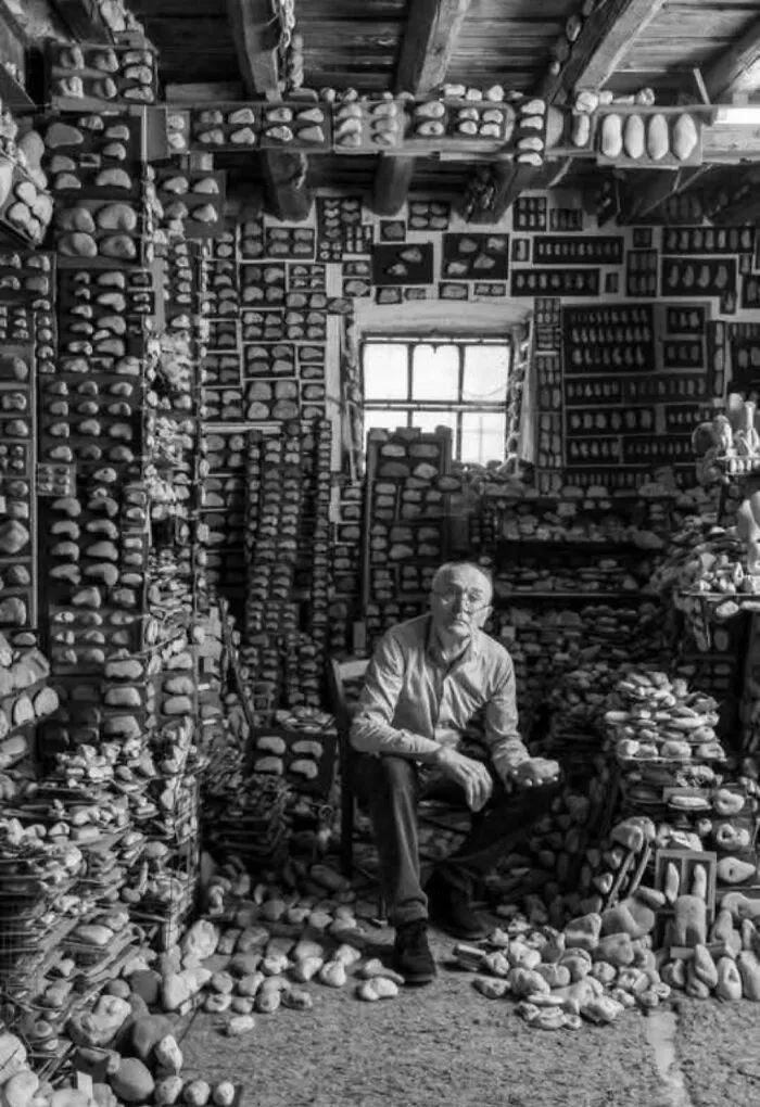 مردی در میان صدها سنگ دسته‌بندی‌شده در اتاقی چوبی | obsessive stone collector photo