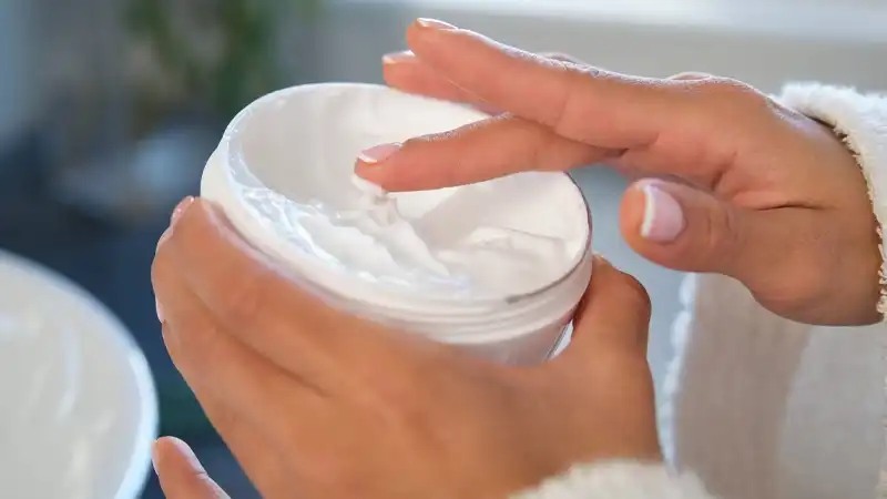 A close-up of a person's hands holding a jar of creamAI-generated content may be incorrect.
